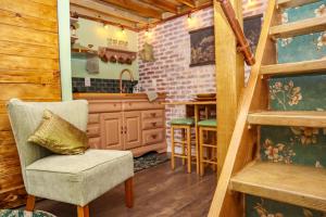 a kitchen with a staircase and a chair in a room at Miami Tiny Vintage Cottage in Hialeah