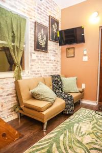 a living room with a couch and a tv at Miami Tiny Vintage Cottage in Hialeah