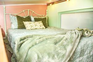 a bedroom with a bed with a blanket on it at Miami Tiny Vintage Cottage in Hialeah