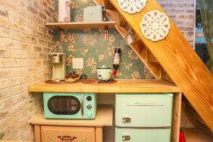 a small kitchen with a microwave and a stove at Miami Tiny Vintage Cottage in Hialeah +6 photos