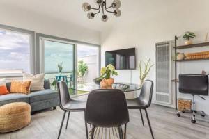 a living room with a couch and a table and chairs at AMAZING OCEAN VIEW - LUXURY Manhattan Beach 1 Bedroom - Parking in Manhattan Beach