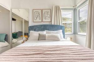 a bedroom with a large bed with a blue headboard at AMAZING OCEAN VIEW - LUXURY Manhattan Beach 1 Bedroom - Parking in Manhattan Beach