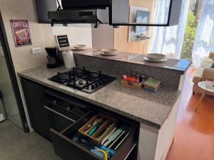 a kitchen with a stove and a counter top at Acogedor apartamento cerca a Unicentro in Bogotá