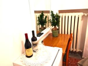 ローマにあるA Casa Simpatia - Check-in Via Bixio, 41のワイン2本(テーブルとグラスの上に座る)