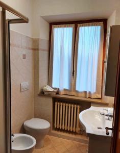 een badkamer met een toilet, een wastafel en een raam bij Casa Bibi-Montepulciano-5 posti in Montepulciano