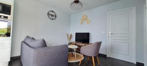ein Wohnzimmer mit 2 Stühlen und einem Tisch in der Unterkunft Les Gîtes Kajou in Bouillante
