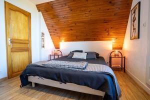 a bedroom with a large bed with a wooden ceiling at Omaha gîtes in Vierville-sur-Mer