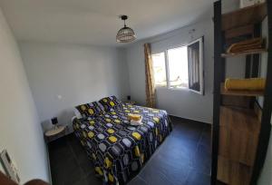 1 dormitorio con cama y ventana en Les Gîtes Kajou, en Bouillante