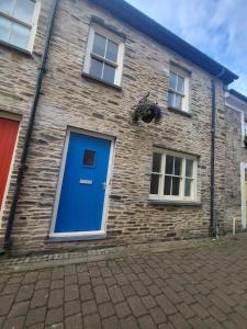 a brick house with a blue door and windows at Stunning seaside town cottage in Cardigan