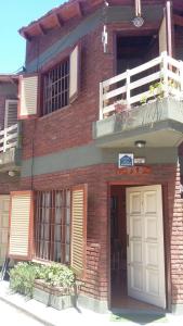 a brick building with a white door and a balcony at Drumond Paradise in San Bernardo