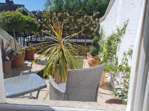 eine Terrasse mit einem Tisch, Stühlen und Topfpflanzen in der Unterkunft Pembroke Guest Suite in Dublin