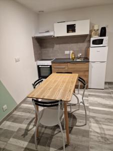 een keuken met een houten tafel en 4 stoelen bij Comme à la maison in Gannat