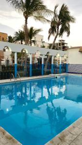 ein großer blauer Pool mit Palmen im Hintergrund in der Unterkunft Beautiful 3BR villa with Self-Check-in near to Major Events Family only in Dschidda