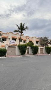 dom z dwoma drzwiami garażowymi i palmą w obiekcie Beautiful 3BR villa with Self-Check-in near to Major Events Family only w mieście Dżudda