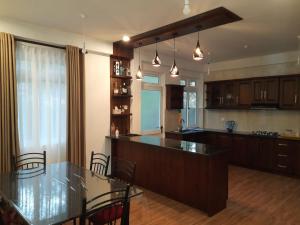 a large kitchen with a table and chairs in it at HEATHER NEST HOMESTAY - KUNDASALE in Kundasale