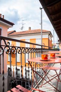 einen Tisch und Stühle auf einem Balkon mit einem Gebäude in der Unterkunft La Sorpresa - luxury apartment in historic city center in Arona