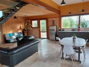 eine Küche und ein Wohnzimmer mit einem Tisch und einem Sofa in der Unterkunft L'atelier in Soucelles