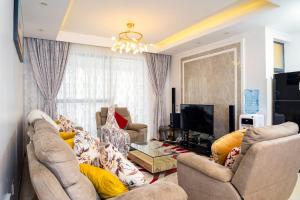a living room with two couches and a television at Sylver Harbour 2 Bedroom Apartment in Nairobi