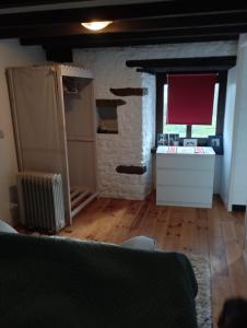 um quarto com uma parede de tijolos e uma cozinha com uma janela em Petit Coin de Paradis Studio em Moyon