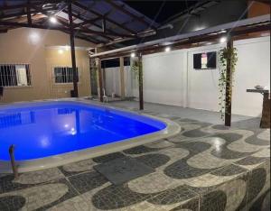 a large blue swimming pool in a building at casa de praia in Macapá
