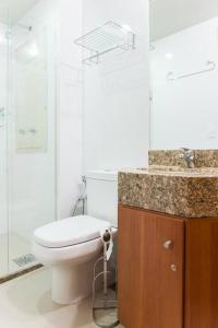 a white bathroom with a toilet and a shower at Monumental Nobile- Apart hotel Central in Brasilia