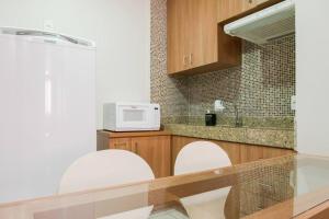 a kitchen with a counter with two chairs and a microwave at Monumental Nobile- Apart hotel Central in Brasilia