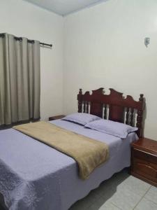 um quarto com uma cama grande e uma cabeceira em madeira em casa de praia em Macapá