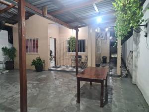 a room with a wooden table and some plants at casa de praia in Macapá