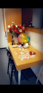 una mesa de madera con un jarrón de flores. en Guesthaus 1, en Dudelange