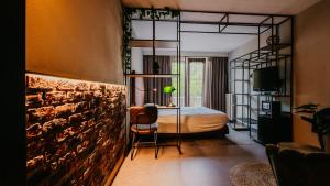 a bedroom with a bed and a rock wall at Hotel De Zeeuwse Stromen in Renesse