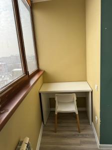 a small desk with a chair in a room with a window at VIP apartments arbat mega in Almaty