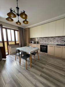 a kitchen with a table and chairs in it at VIP apartments arbat mega in Almaty