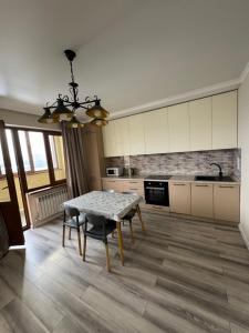 a kitchen with a table and a dining room at VIP apartments arbat mega in Almaty