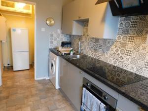 a kitchen with a sink and a washing machine at Quirky Retro 2 bed Apt in Anniesland West End in Glasgow