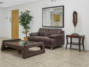 a living room with a brown couch and a table at South River Suites in Medley