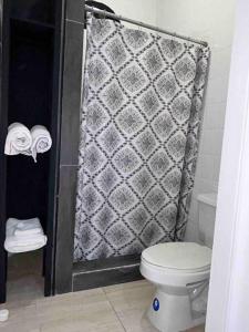 a bathroom with a shower with a toilet and towels at Southsea Seniors Retirement Resort & Villa in Kings Pen