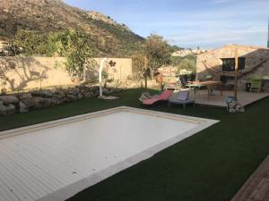 un patio trasero con piscina y césped en A Casa Assulanatta en Santa-Reparata-di-Balagna