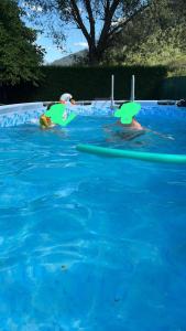 duas pessoas numa piscina com pás na água em MAISON BONHEUR em Villaret