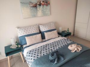 a bedroom with a bed and two tables with pillows at Apartament Nawigator Rybacka 12 b/59 in Kołobrzeg