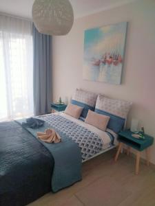 a bedroom with a large bed and a painting at Apartament Nawigator Rybacka 12 b/59 in Kołobrzeg