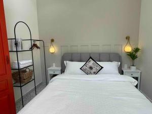 een slaapkamer met een wit bed en 2 nachtkastjes bij Holi Dolce Vita Pool Villa in Nha Trang