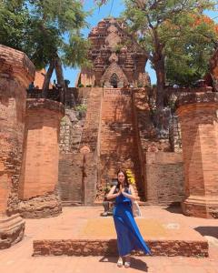 een vrouw in een blauwe jurk die voor een gebouw staat bij Holi Dolce Vita Pool Villa in Nha Trang