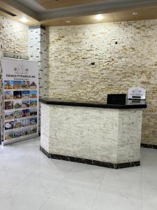 a lobby with a counter and a brick wall at Prince Pyramids Inn in Cairo