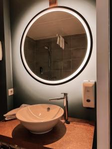 a bathroom with a bowl sink and a mirror at Hotel De Zeeuwse Stromen in Renesse