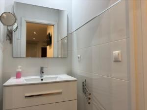 uma casa de banho branca com um lavatório e um espelho em Apartamento Medina-Azahara em Córdoba