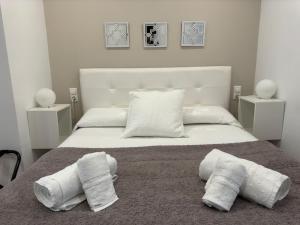 1 dormitorio blanco con 2 toallas en una cama en Apartamento Medina-Azahara en Córdoba