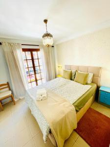 a bedroom with a large bed and a chandelier at Apartamento Centro Torremolinos con Solarium in Torremolinos