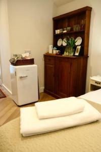 a room with a small refrigerator and a shelf with plates at Barton Hollow in Barton on Sea