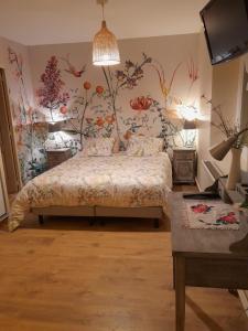 1 dormitorio con 1 cama con flores en la pared en Flopre chambre d'hote, en Flocourt