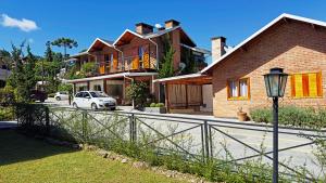 a white car parked in front of a house at Pousada Charme da Montanha in Monte Verde